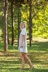 Fashion style portrait of gorgeous beautiful woman posing in summer green park