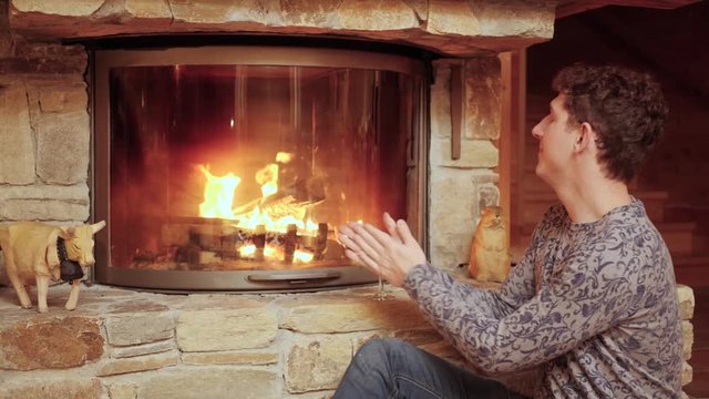 Relaxing Cozy Cabin. Man Sits with a Glass of Wine.