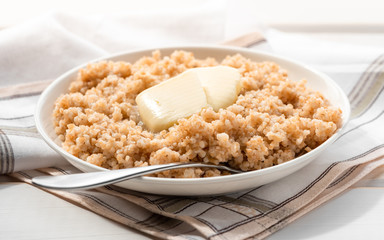 Boiled spelt with butter and honey. Healthy breakfast.