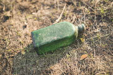Garbage in the Park or forest, an empty bottle lying on the ground. The concept of environmental pollution, environmental problems of nature.