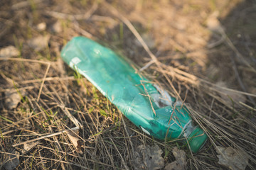 Garbage in the Park or forest, an empty bottle lying on the ground. The concept of environmental...