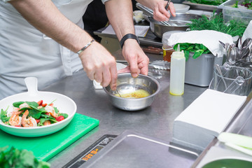 View of the hands of the cook who prepares the sauce for salad dressing