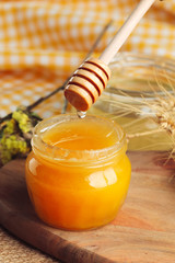 Honey background. Sweet honey in glass jar on wooden background.