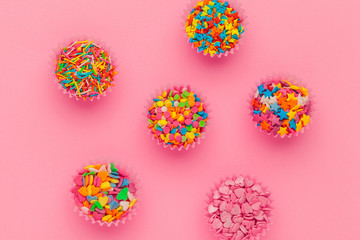 Sugar sprinkles, decoration for cake and ice-cream and cookies on pink background