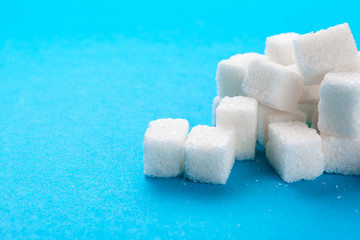 White sugar cubes on a bright blue background