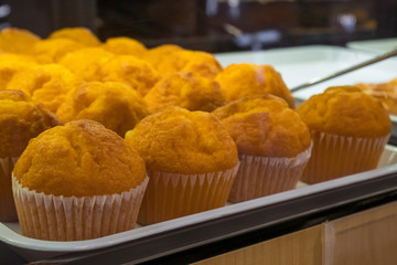 Assorted muffins arranged on tray at bakery shop.