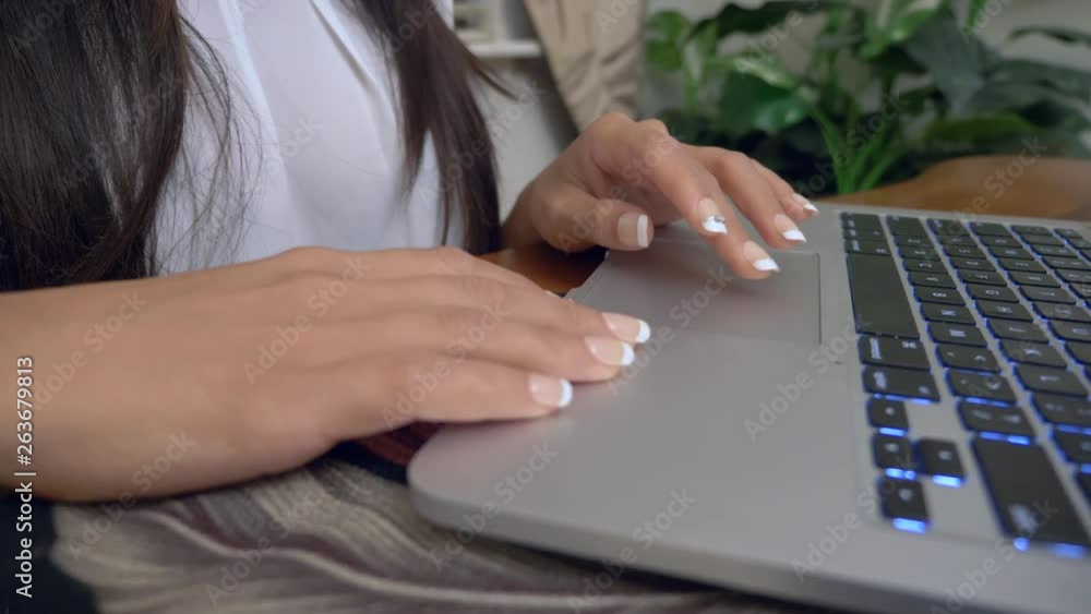 Poster close up of female hands using computer as camera slides right.