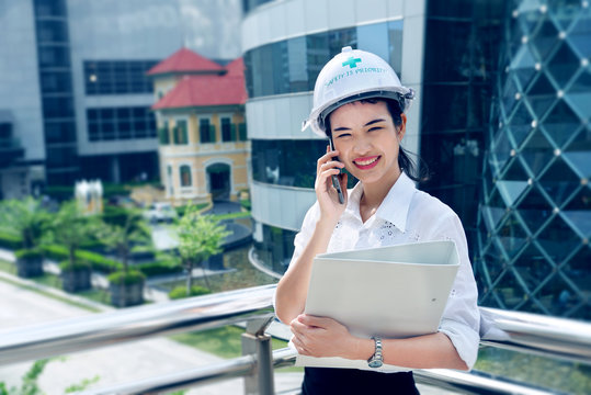 Engineer woman working holding floder and takling with client from smartphone