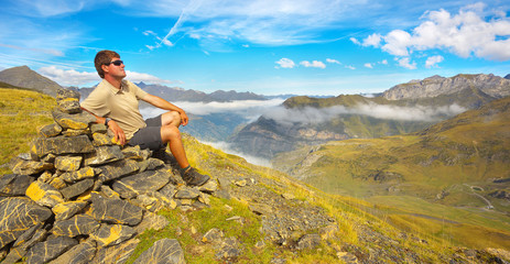 Pyrenees; mountain; tourist; resting; sitting; man; relax; relaxing; watching; deep; valley; hiking; outdoor; landscape; Occidentales; rocks; rocky; fog; France; highland; level; stones; stony; upland