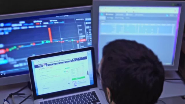 Man check multi monitor for cryptocurrency investing