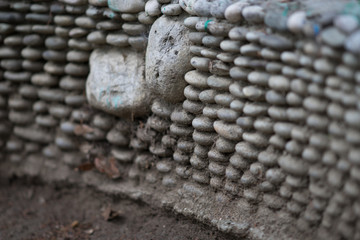 The wall is the basis of the bench for the seats made of round pebble stones