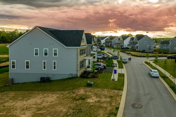 Aerial view of typical American new construction neighborhood street in Maryland for the upper middle class, single family homes USA real estate with dramatic sky