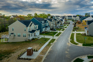 Aerial view of typical American new construction neighborhood street in Maryland for the upper middle class, single family homes USA real estate with dramatic sky