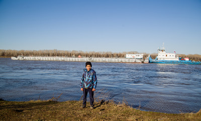 Fototapeta premium kid on the background of the tugboat