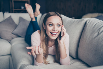 Closeup photo portrait of cheerful positive cute lovely talkative with beaming toothy smile gesturing hands lying down on divan in denim trousers barefoot