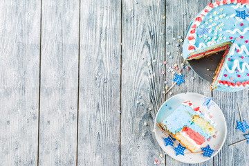 Homemade American United States  Independence day cake, for 4 July party, with sugar stars, striped cream decoration, wooden background copy space