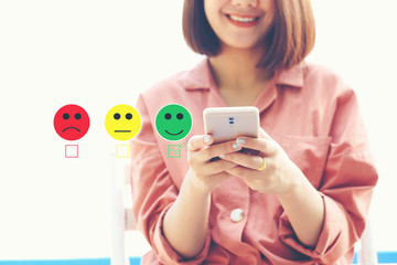 Woman using smart phone and putting check mark with smiley face marker in coffee shop, Satisfaction...