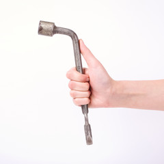 Wheel wrench in hand of the girl. Symbol of hard work, feminism and labor day. Isolate on white background.