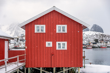 Red house of scandinavian style in snowfall on winter