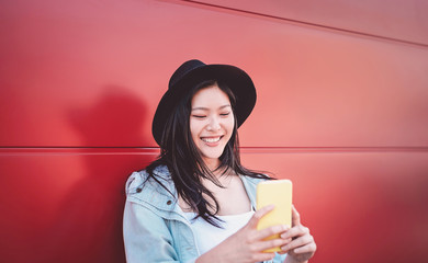 Happy Chinese girl using mobile phone outdoor - Asian social influencer woman having fun with new trends smartphone apps - Generation z, media, technology and youth millennial people lifestyle