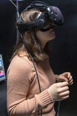 Enthusiastic glad positive girl in virtual reality glasses in quest room