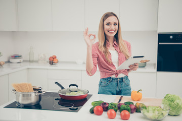 Close up photo beautiful she her lady hold hands arms e-reader okey symbol check quality advising food prepare expert wear domestic home apparel shirt jeans denim outfit bright home kitchen indoors