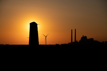 Fossil fuel and wind power in dramatic red sun set sky shot from Amager F&aelig;lled, Aved&oslash;rev&aelig;rket Copenhagen, Denmark 