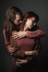 Young passionate couple in love on the gray background