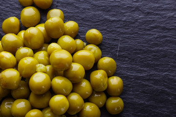canned green peas on a dark stone background