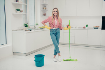 Full length body size photo beautiful nice duties funky she her lady wash white shiny floor finished work wait check expert mind wear jeans denim casual checkered plaid shirt bright light kitchen