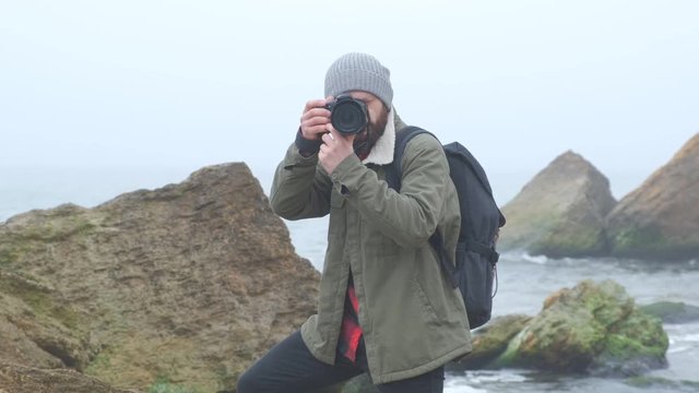 Outdoorsy photographer with a beard capturing a stormy sea