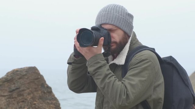 Outdoorsy photographer with a beard capturing a stormy sea
