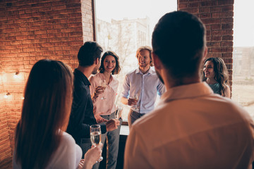 Company of nice lovely attractive pretty elegant cheerful cheery positive guys ladies having fun talking congrats greetings occasion in wood brick industrial loft interior room indoors