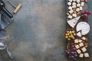 Cheeseboard with various cheeses, grapes, olives and nuts