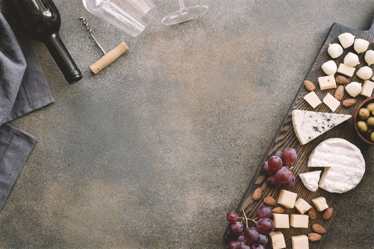 Cheeseboard With Various Cheeses, Grapes, Olives And Nuts