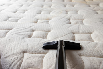 Fototapeta premium cleaning dirty mattress by vacuum cleaner. dust mites on bed, texture. concept : allergy in bed room.