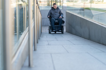 Man in a electric wheelchair using a ramp