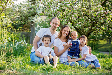 Fashionable big family, having their spring portrait taken with little bunnies