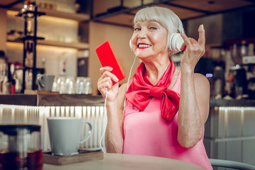 Joyful positive aged woman enjoying rock music