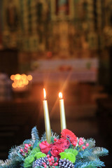 Cierges sur une couronne de fleurs. / Candles on a wreath.