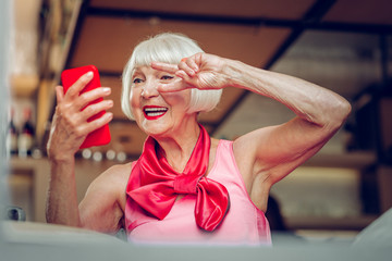 Happy nice aged woman chatting on video