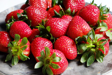 Ripe local produce organic strawberry. Heap of red berries on plate. Fresh healthy vegan dietary food for spring detox. Fruits background, top view. Clean eating concept.