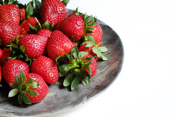 Ripe local produce organic strawberry. Heap of red berries on plate. Fresh healthy vegan dietary food for spring detox. Fruits background, top view. Clean eating concept.