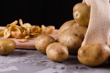 A young woman in an apron peeling potatoes