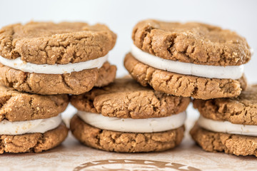 A stack of round baked gingerbread cookies with a white creamy filling
