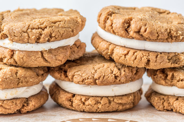A stack of round baked gingerbread cookies with a white creamy filling