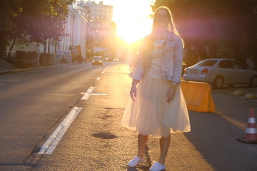 Obraz premium Beautiful girl posing in the streets of city at sunset