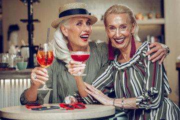 Delighted stylish aged women meeting in the restaurant