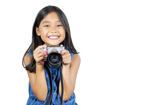 Isolated photo of an Asian girl smiling happily while holding her camera.