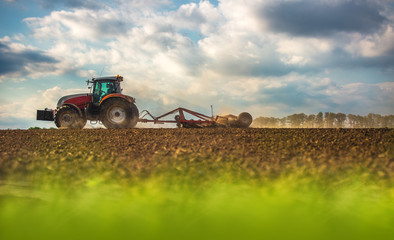 Farmer in tractor preparing land with seedbed cultivator